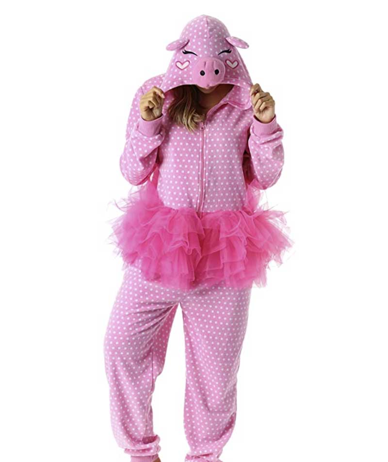 woman in a one piece pajama outfit that is pink with polka dots and an attached tutu. There is a cartoon pig face on the hood of the onesie.