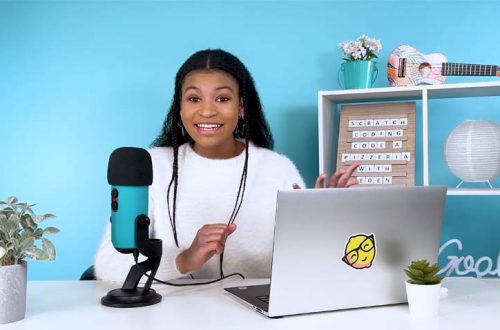 girl sitting at a desk in front of a microphone and computer